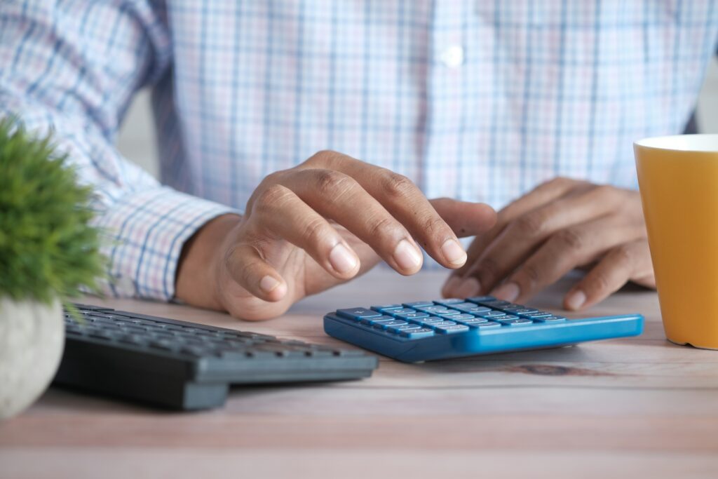 Person using calculator for zero-based budget planning